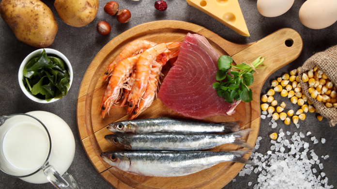 Pescado, gambas, carne y leche ricas en yodo en una mesa