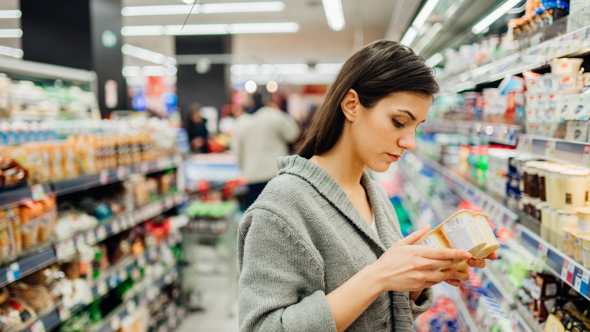 Donna anemica che controlla la composizione nutrizionale di un alimento in un negozio