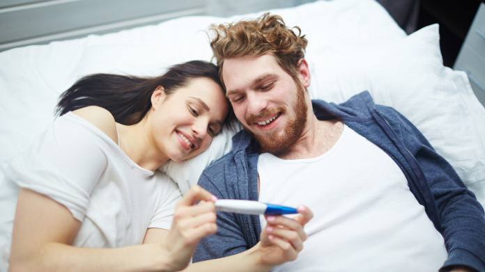 Casal fértil que observa um teste de gravidez positivo