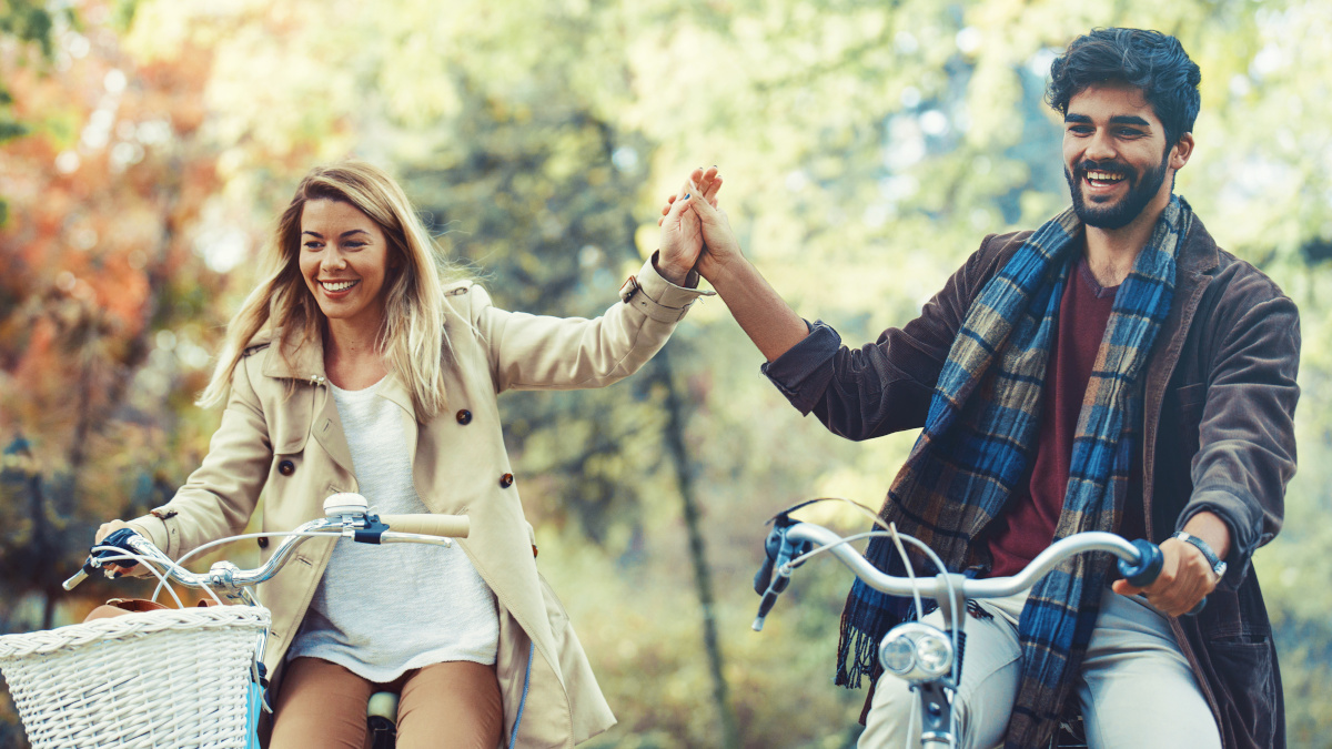 Couple énergique à vélo dans la forêt en automne