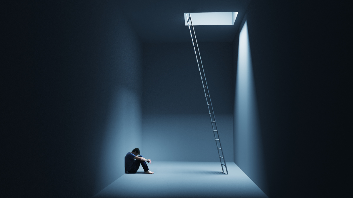 Hombre en crisis de ansiedad sentado cerca de una escalera