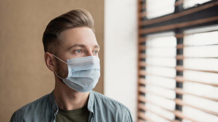 Depressieve man met mondmasker tijdens COVID-19-pandemie