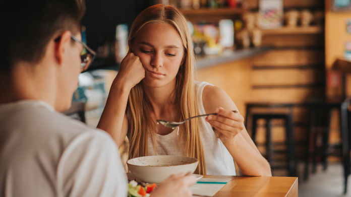 Femme blonde fatiguée en train de manger