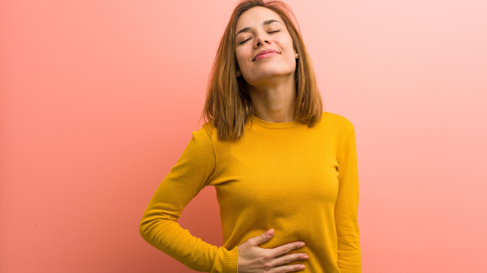 Mujer aliviada que digiere la comida