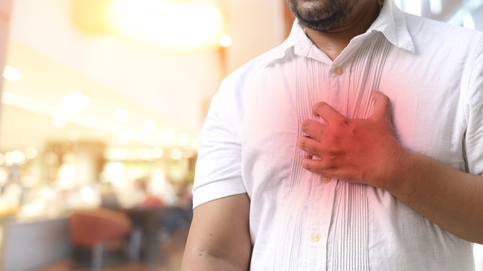 Hombre en camisa que tiene un fuerte dolor en el pecho