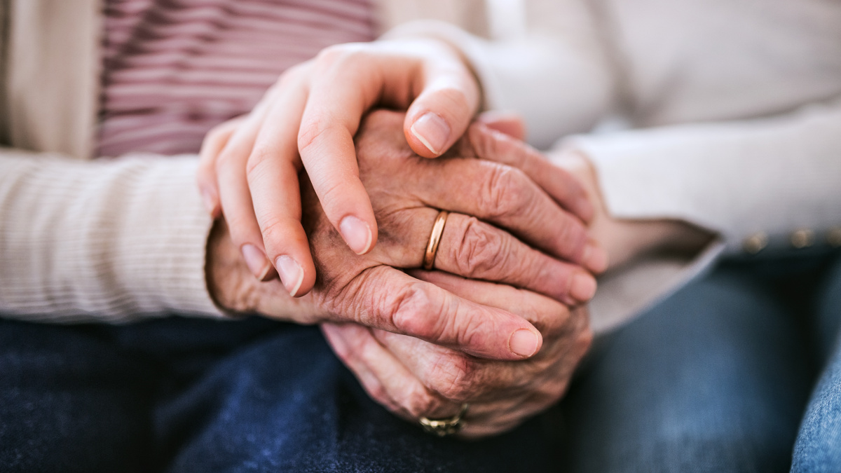 Segni dell'invecchiamento sulle mani rugose e macchiate di una persona anziana