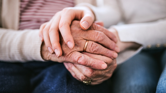 Signos de envejecimiento en las manos arrugadas y con manchas de una persona mayor
