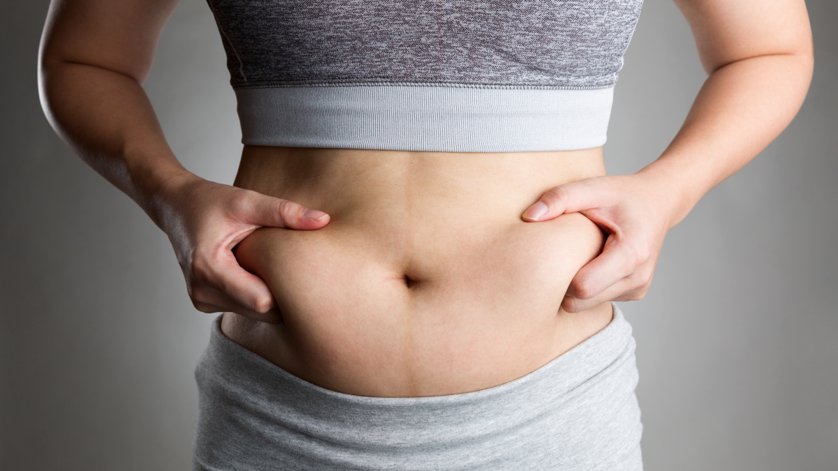 Biegająca kobieta z widoczną „oponką” tłuszczu na brzuchu