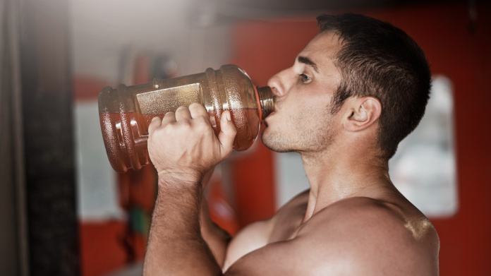 Bodybuilder drinking a homemade pre-workout 