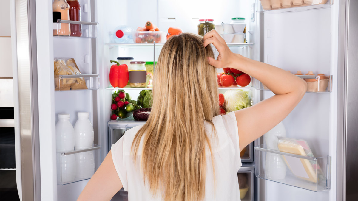 Fotografia de uma pessoa à procura de algo no frigorífico